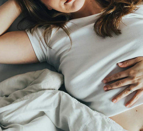 Jeune femme enceinte tenant tendrement son ventre au début de sa grossesse.  - Mustela Belgium - 1