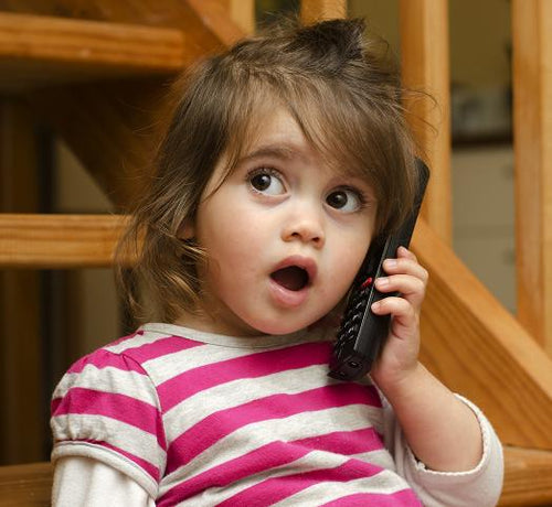 Enfant fille brune avec un téléphone portable à l'oreille - Mustela Belgium - 1