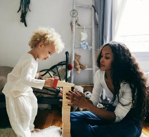 Enfant debout jouant avec sa maman au kapla en bois - Mustela Belgium - 1