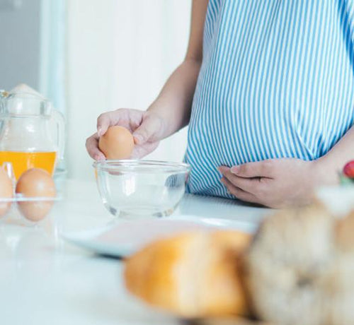 Photo d'une femme enceinte qui casse un oeuf contre un bol - Mustela Belgium - 1