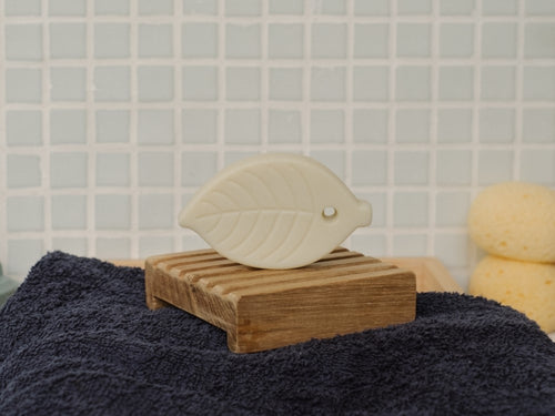 Le savon solide Shampoing Douche  est posé sur un porte-savon dans une salle de bain - Mustela Belgium - 2
