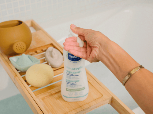 Stelatopia Gel Lavant anti-tiraillements, placé aux côtés de produits de salle de bains. - Mustela Benelux - 4