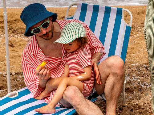 papa qui applique un stick solaire sur son enfant à la plage - Mustela Benelux - 2
