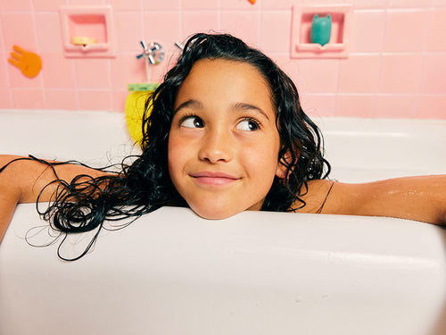 Petite fille dans son bain avec ces cheveux long ondulés et mouillé - Mustela Belgium - 3